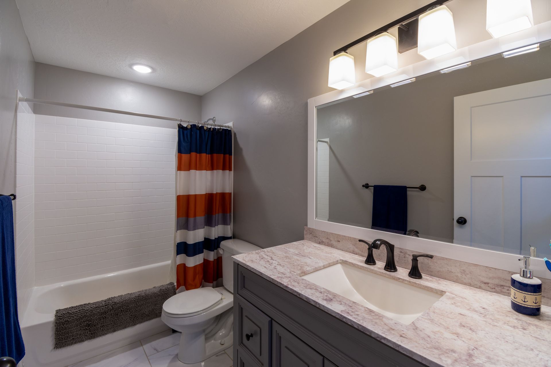 Bright and minimalist bathroom with a modern vanity and colorful shower curtain.